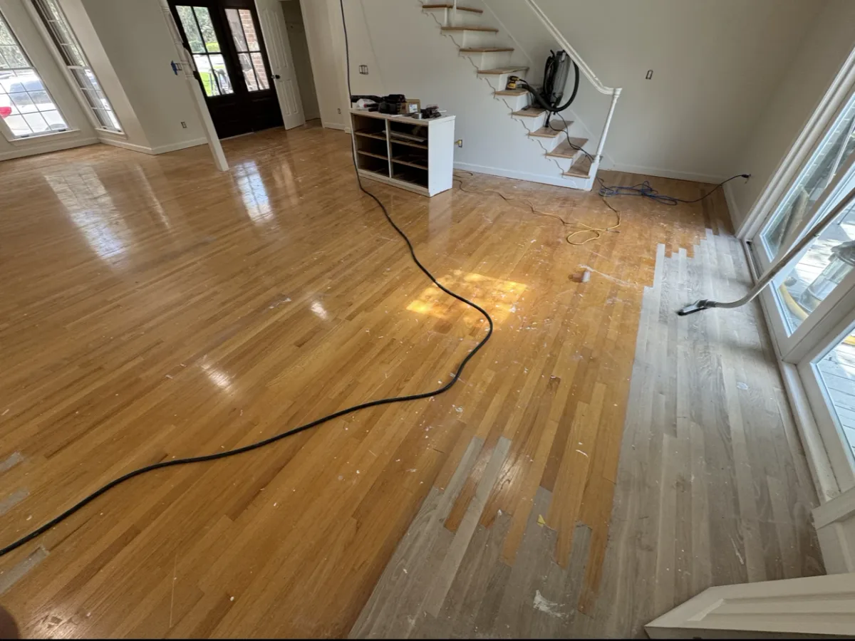 A living room floor part way through, the old finish coming off